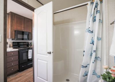 Model bathroom with shower at Aldea Manufactured Home Community in Fort Worth, Texas