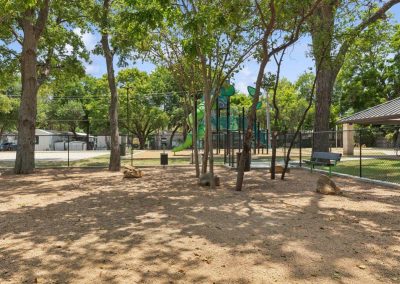 Fenced in dog park with benches at Aldea Manufactured Home Community in Fort Worth, Texas