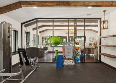 Resident fitness center with equipment at Aldea Manufactured Home Community in Fort Worth, Texas